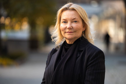 Portrait of Veronika Lindstrand Kant, Manager for a Coherent Reception System. She stands outside in a dark shirt and a dark jacket.