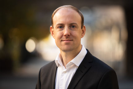 Portrait of Eric Ramstedt, Director Planning Department. He stands outside in a light shirt and a dark jacket.