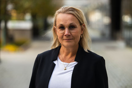 Portrait of Linda Widmark, Director Communication Department. She stands outside in a light shirt and a dark jacket.